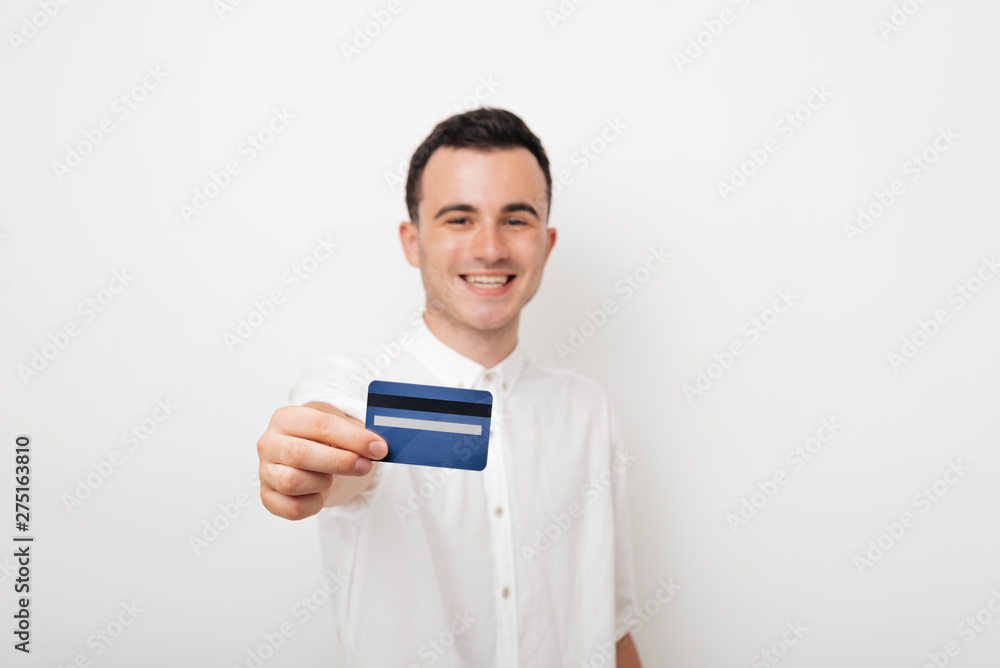 cheerful young man in white suit holds a card credit cheerful young man in white suit holds a card credit