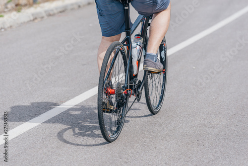 A caucasian male biker rides his bike uphill, wearing professional biking mountain biking gear © qunica.com