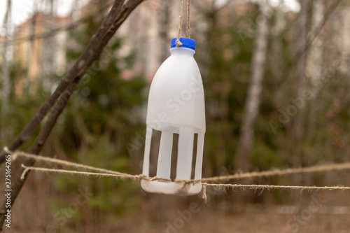 Kids-made homemade bird feeder in the park. Feeding trough from a plastic bottle.