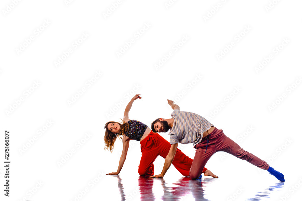 Two talented dancers practicing in large studio, isolated on white