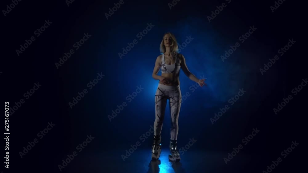 Pretty woman performing exercises in kangoo jumps. Slow motion Pretty woman performing exercises in kangoo jumps. Slow motion