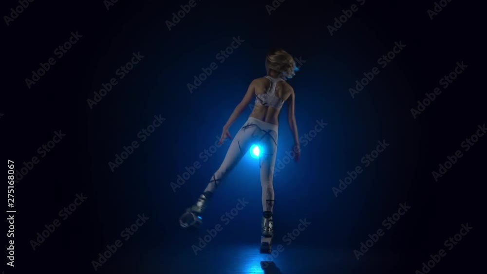 Slow motion of girl jumping in kangoo jumps shoes against blue spotlight.