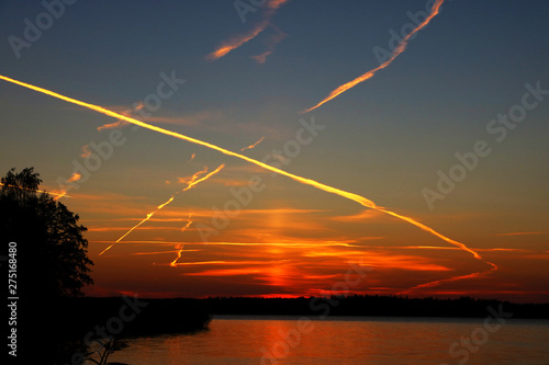 Dramatic beautiful sunset and sunrise. Traces of the aircraft