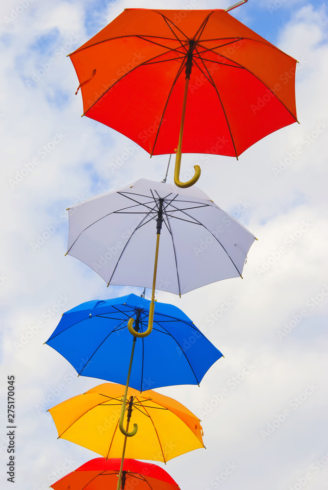 Open bright umbrellas against the sky