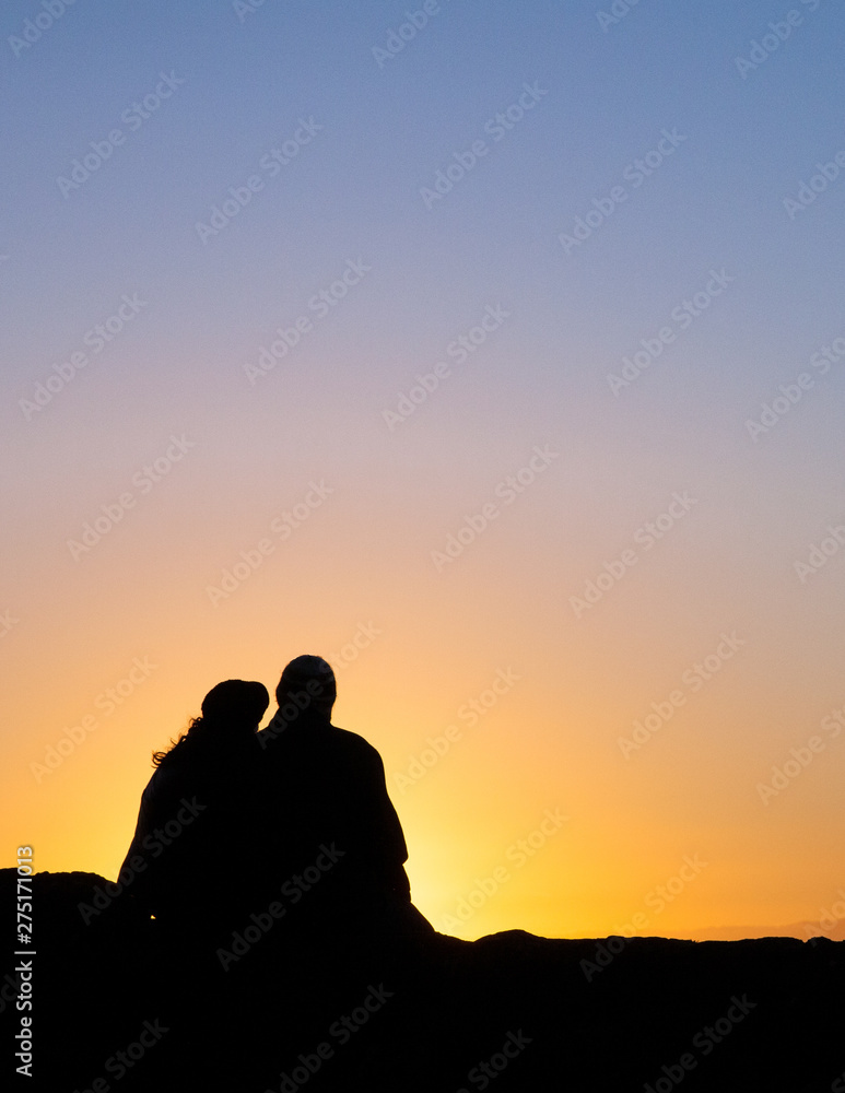 A couple watches a sunset.