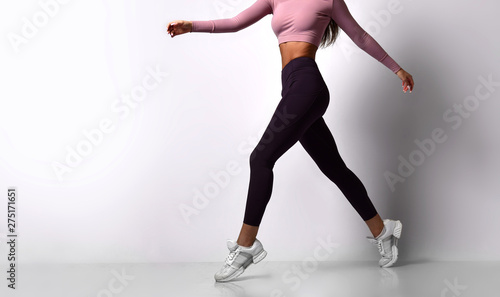 Sporty woman legs walking in sport wear on a white