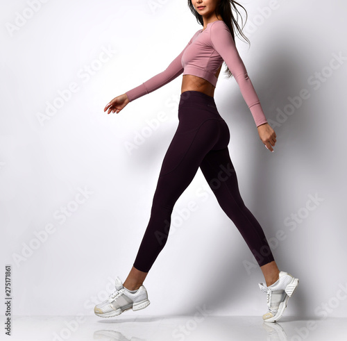 Sporty woman legs walking in sport wear on a white photo