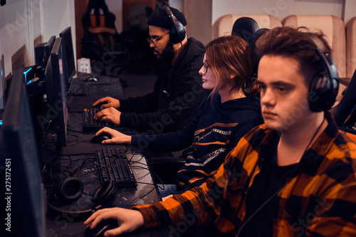 Adult tired boys and girl are playing videogames at popular cyber championship. photo