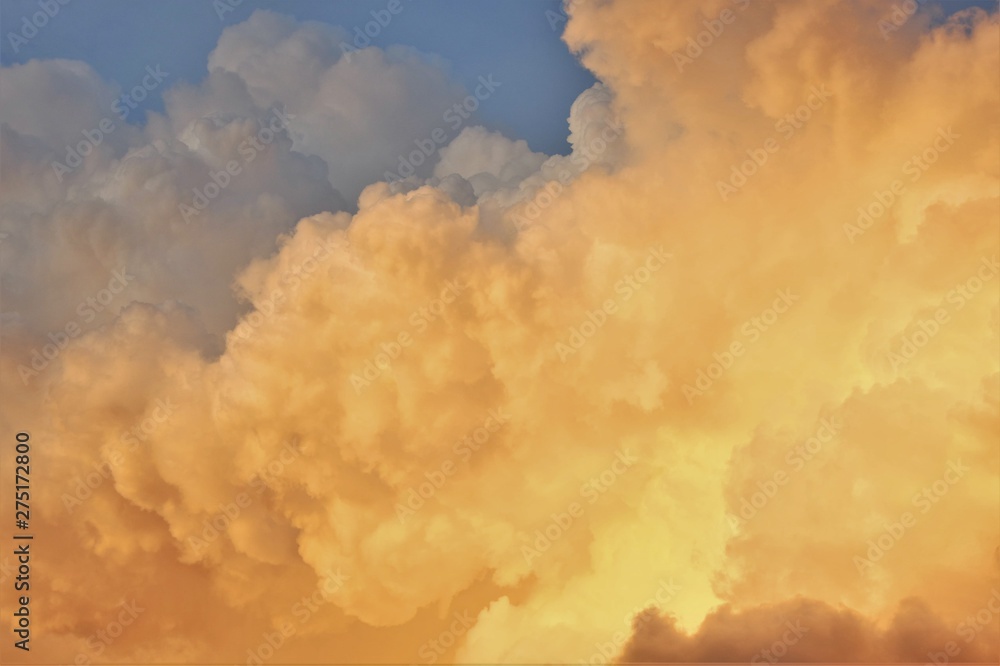 cumulus clouds white and orange and blue sky at sunset