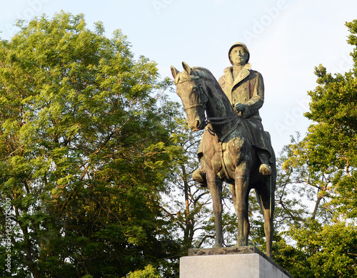 Old bronze statue of King Albert 1, third king of the belgians, on his horse surrounded by spring trees on a sunny day in May in Bruges, Belgium photo