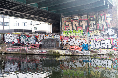 Hackney, East London, England, UK - April 2019: Murals and graffiti below a railway bridge along Regent's canal near Broadway Market, East London © drimafilm