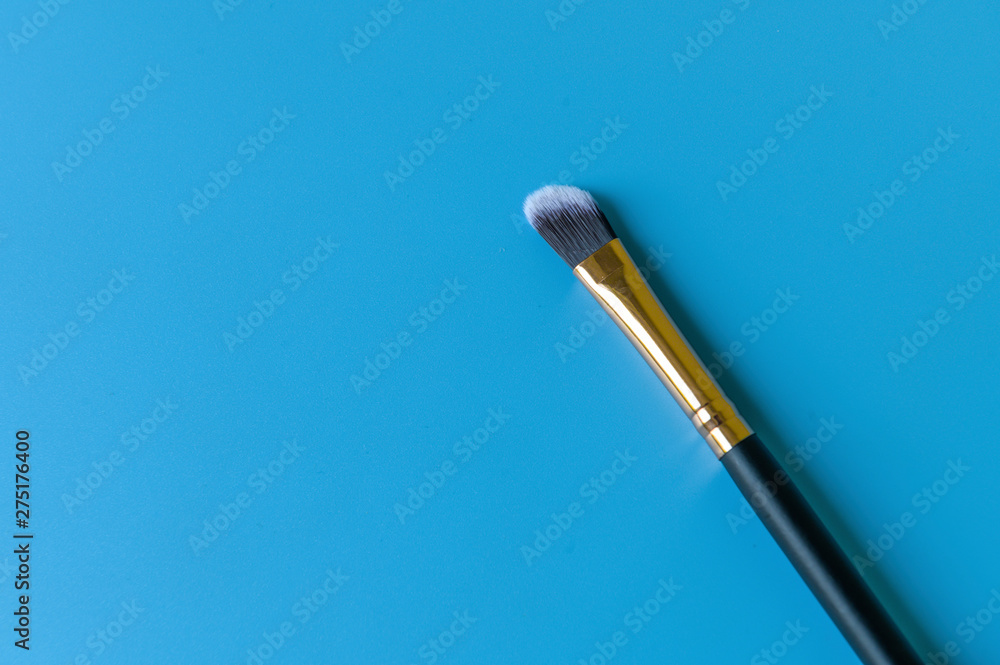 Naklejka premium Makeup brush on a blue background