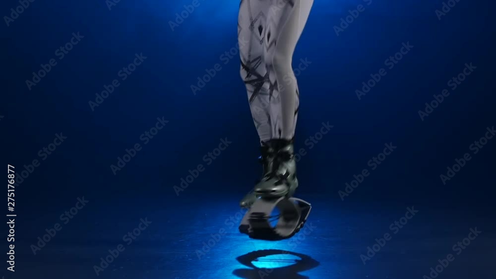 Сardio training in kangoo shoes against blue spotlight. Close-up slow motion Сardio training in kangoo shoes against blue spotlight. Close-up slow motion