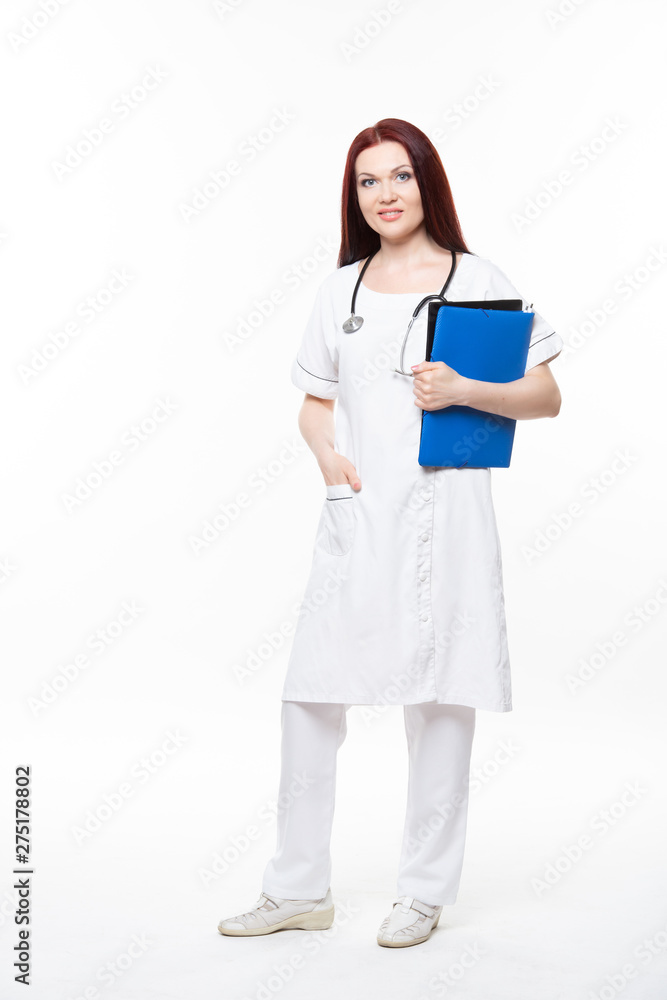 Happy young female family doctor holds blue folder with documents, has friendly expression, isolated white background. Medicine concept. Happy young female family doctor holds blue folder with documents, has friendly expression, isolated white background. Medicine concept.