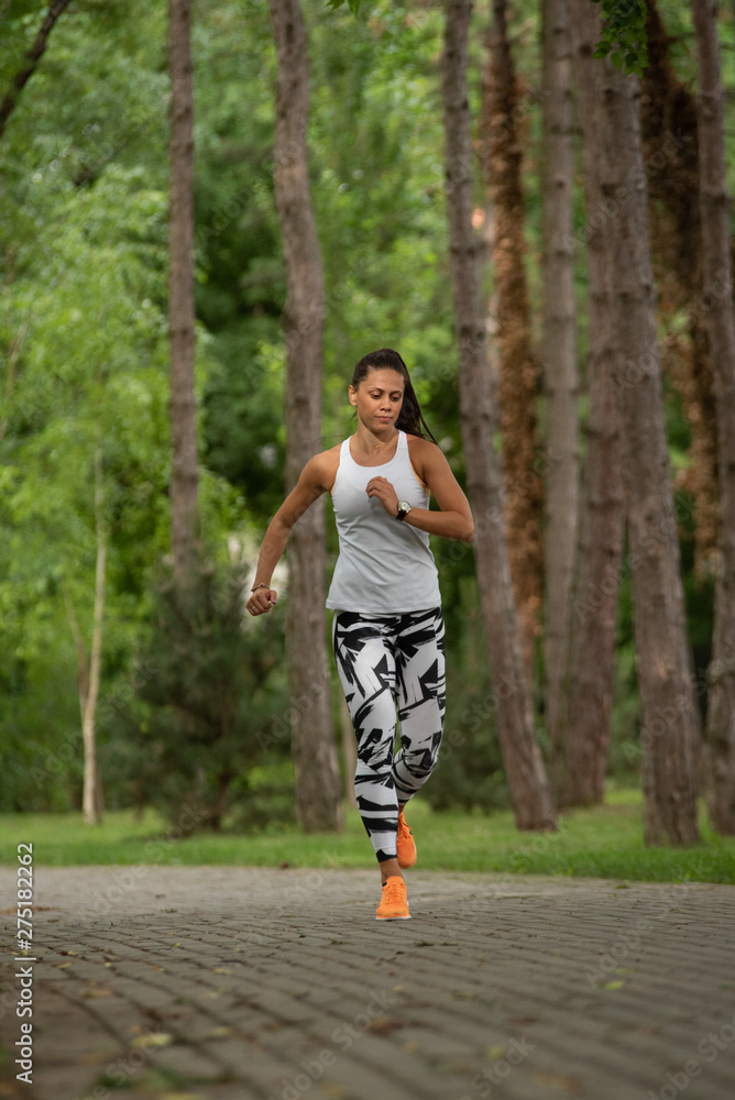 A beautiful fitness girl runs in the park. Nature and healthy life A beautiful fitness girl runs in the park. Nature and healthy life