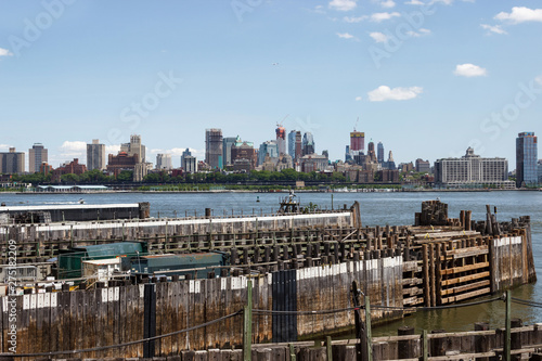 On the horizon are seen the skyscrapers of New York. Skyscrapers of New York in the distance. Bay, blue sky, sunny summer day in New York. © Liudmila