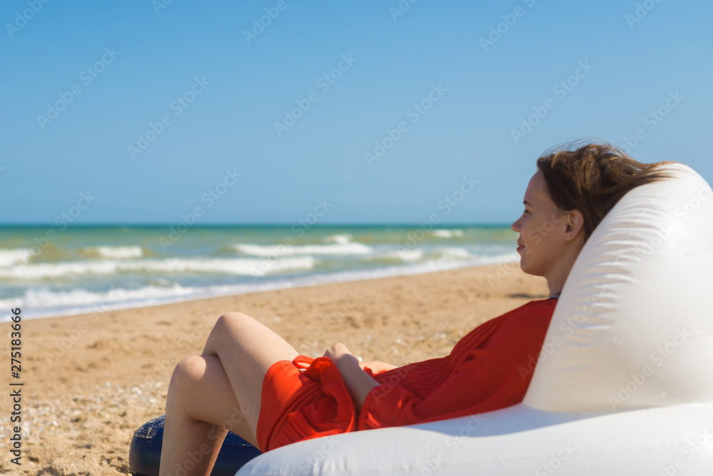 A woman is resting on the sea while sitting in an inflatable chair