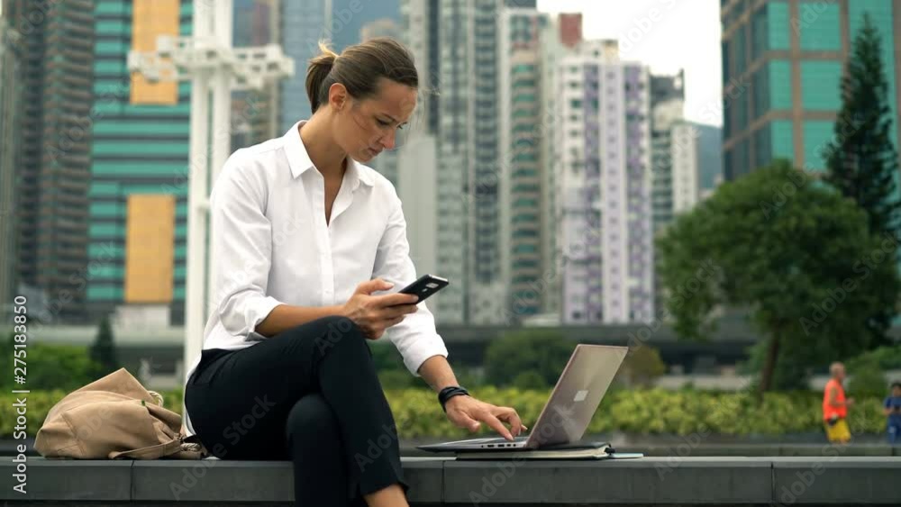 Young businesswoman working with smartphone and laptop in city Young businesswoman working with smartphone and laptop in city