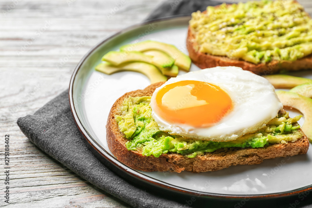 Plate with tasty avocado toasts on table, closeup