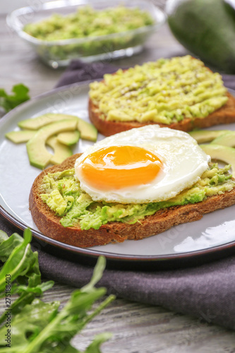 Plate with tasty avocado toasts on table, closeup