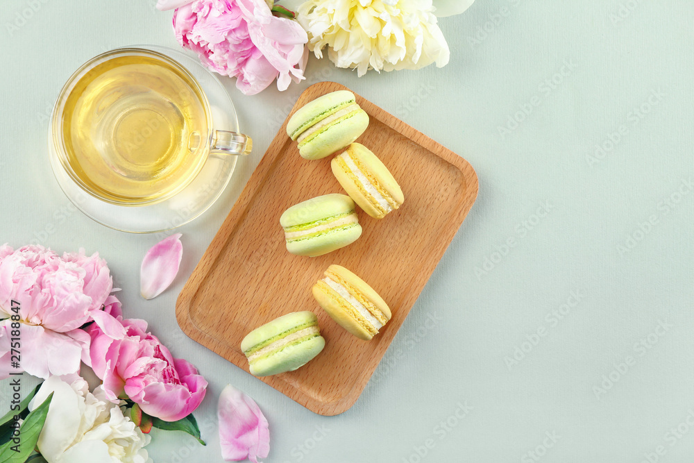 Beautiful peony flowers, cup of tea and macarons on light background Beautiful peony flowers, cup of tea and macarons on light background