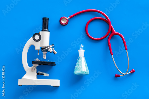 Medical research with microscope, stethoscope, test tube on blue background top view