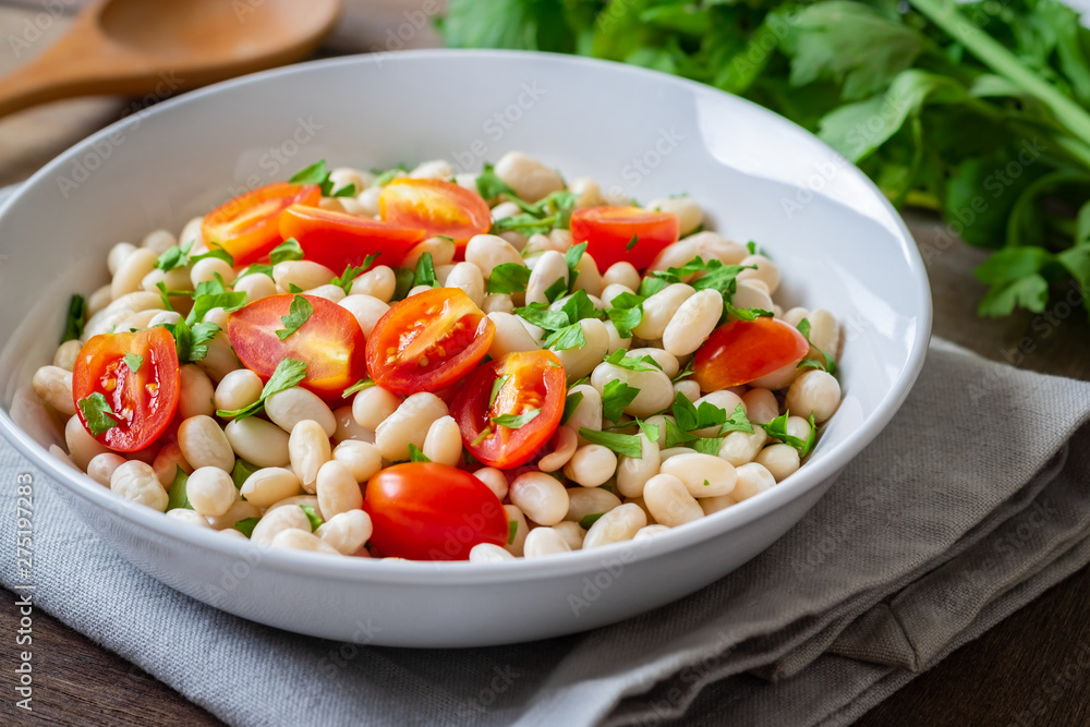 White bean salad with cherry tomatoes and parsley in bowl White bean salad with cherry tomatoes and parsley in bowl