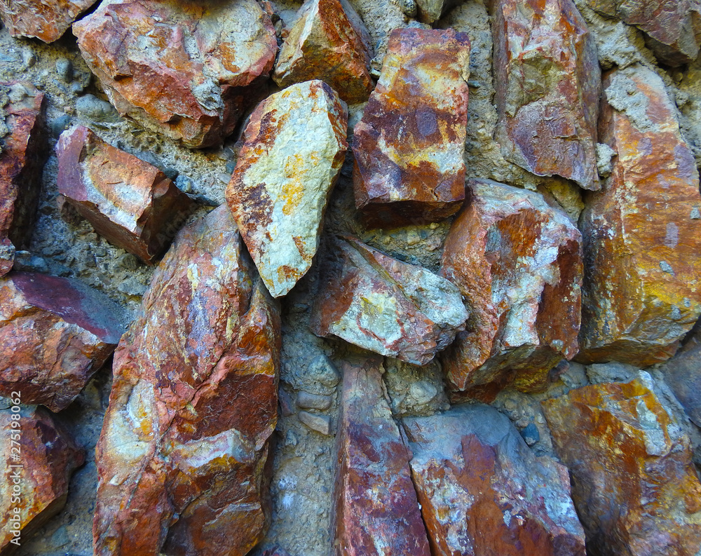 The wall is made of natural stones. Background. Texture. The wall is made of natural stones. Background. Texture.