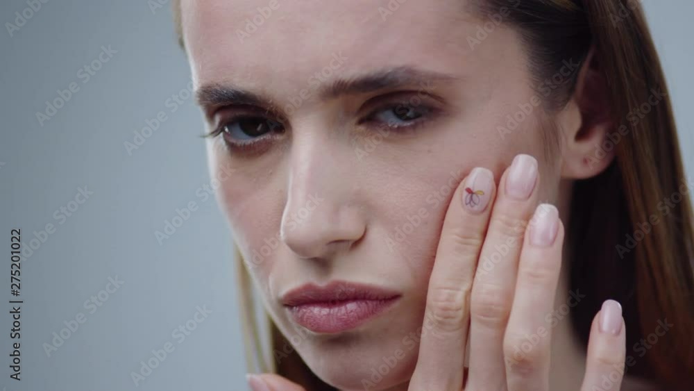 Face woman look carefully at camera lead by hand on the face grey background care skincare female perfect studio adult attractive girl makeup model cute pretty portrait close up slow motion Face woman look carefully at camera lead by hand on the face grey background care skincare female perfect studio adult attractive girl makeup model cute pretty portrait close up slow motion