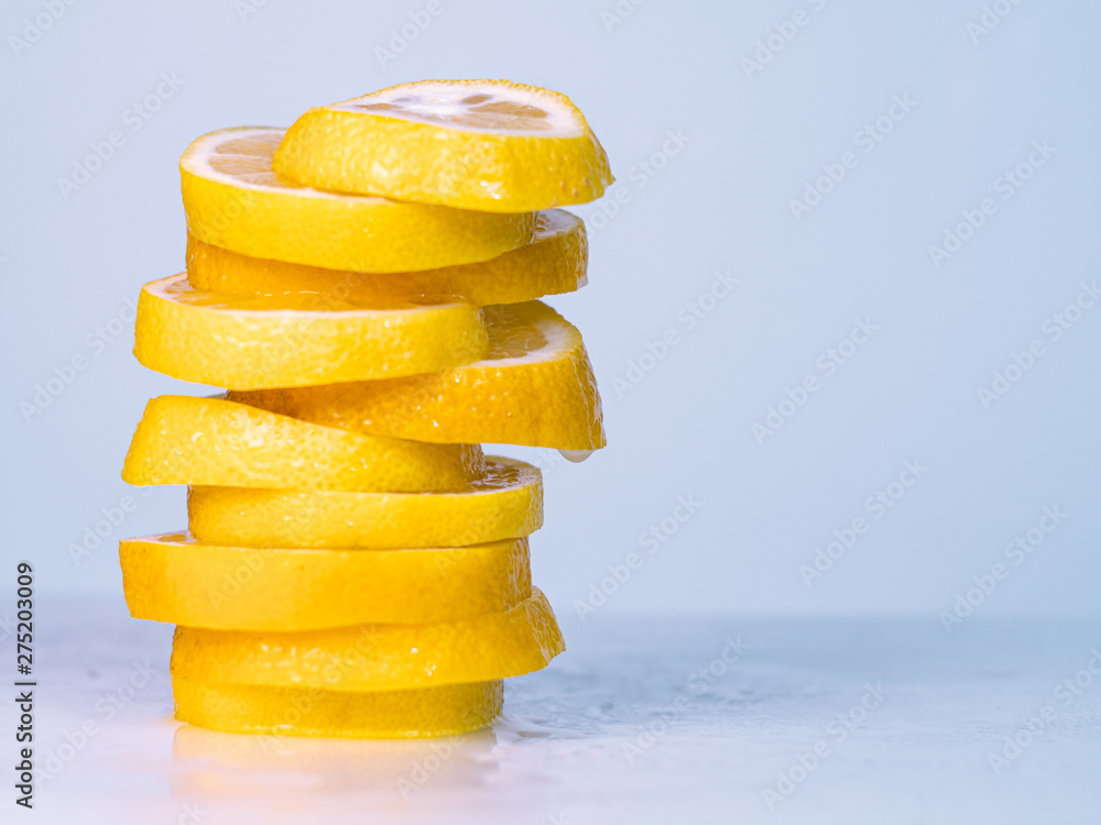 Yellow cutted lemon on light background, close up view. Pile of lemon slices with lemon juice dropping on light table. Blurred background. Selective soft focus Yellow cutted lemon on light background, close up view. Pile of lemon slices with lemon juice dropping on light table. Blurred background. Selective soft focus