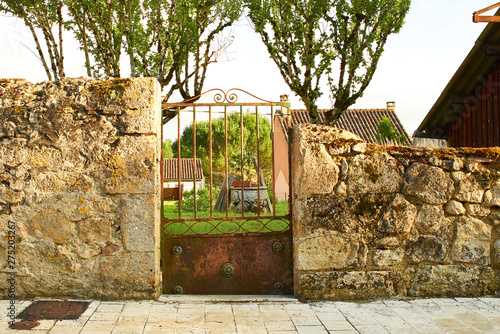 Portillon, mur de pierre, aperçu sur le jardin Photos | Adobe Stock