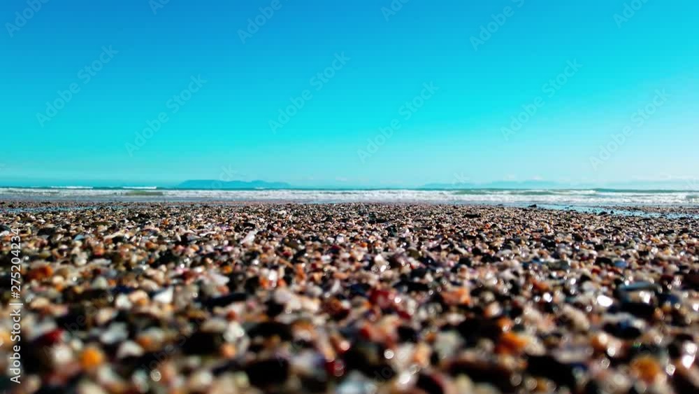 Close Up: Turquoise ocean waves roll in on the peaceful shore with sea birds in the background. View of swell reaching sandy beach. Close Up: Turquoise ocean waves roll in on the peaceful shore with sea birds in the background. View of swell reaching sandy beach.
