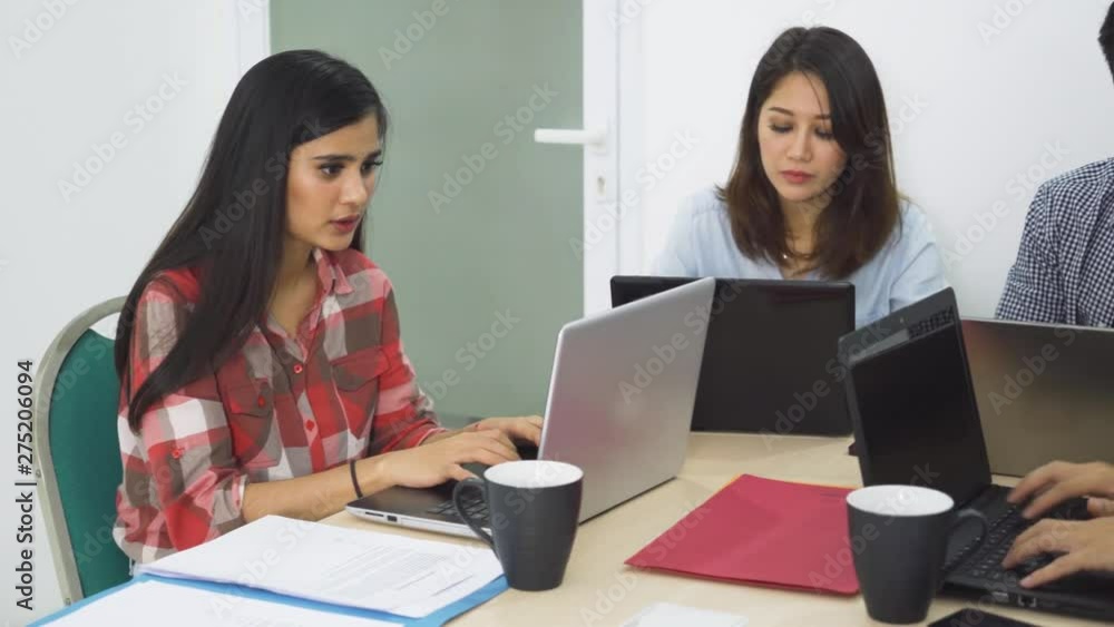 Group of young business team working together with laptop computer on the table in the office. Shot in 4k resolution Group of young business team working together with laptop computer on the table in the office. Shot in 4k resolution