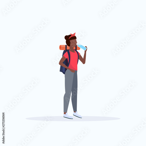 Woman hiker with backpack drinking water African