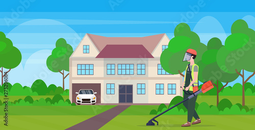 man gardener in uniform cutting grass with brush cutter gardening concept modern cottage house countryside background full length flat horizontal