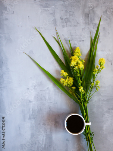 Cup of coffee and wild flowers on light background  top view. Cozy Breakfast. Flat lay .
