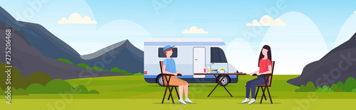 couple sitting at table near camping family trailer truck caravan car man woman spendingtime togeher summer vacation concept beautful nature landscape background flat full length horizontal