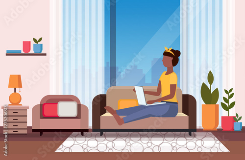 woman sitting on couch using laptop social media network communication digital gadget addiction concept modern living room interior flat full length horizontal