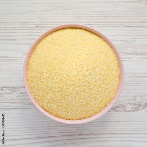 Quadro su tela Top view, dry semolina durum flour in a pink bowl over white wooden surface