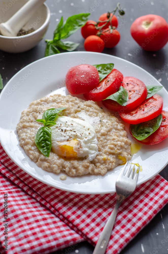 oatmeal with poached egg, tomatoes and basil. fresh tasty proper nutrition meal. healthy food for breakfast oatmeal with poached egg, tomatoes and basil. fresh tasty proper nutrition meal. healthy food for breakfast