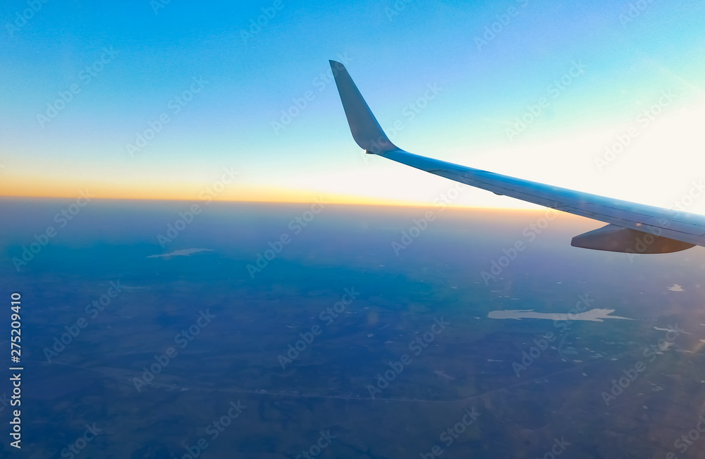 Fototapeta premium wing of an airplane flying above the clouds