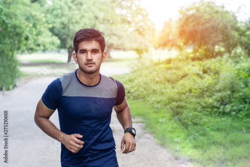 Athletic young man running in the sports ground. Healthy lifestyle , fitness and sports concept.