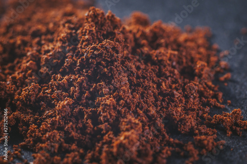 Real natural ground brewed coffee with particles in powder on a dark background, close-up