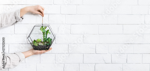 Mini glass geometric vase in woman's hands, copy space