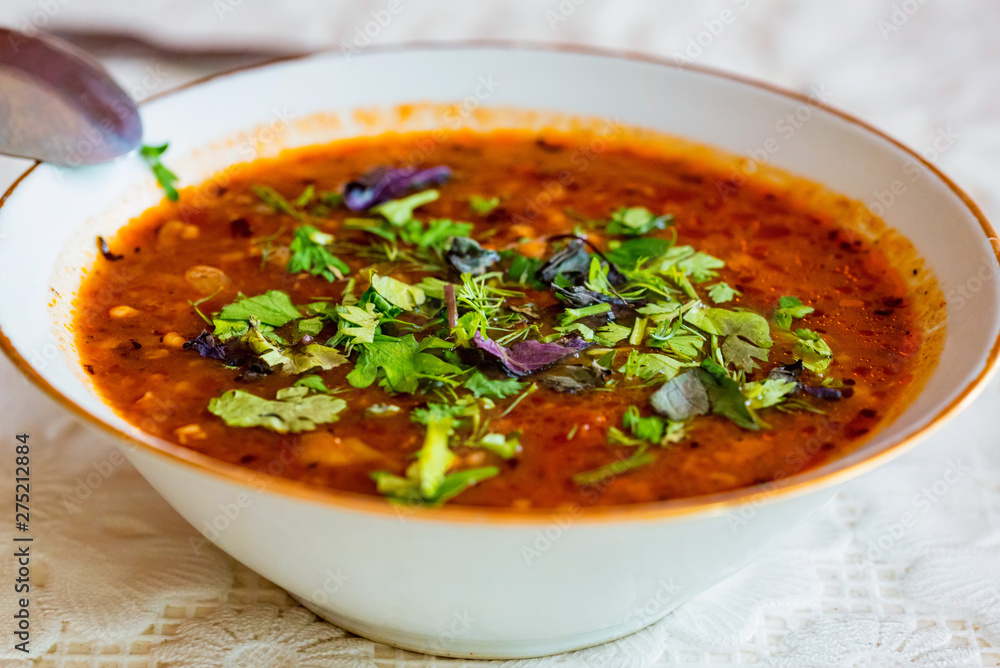 Traditional Georgian soup Kharcho with greenery in plate close Traditional Georgian soup Kharcho with greenery in plate close