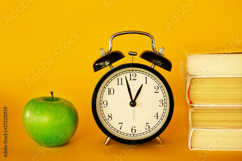 Retro style clock alarm clock on yellow background. Student brunch healthy meal