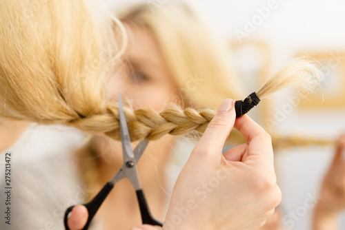 Woman cutting blond braid hair