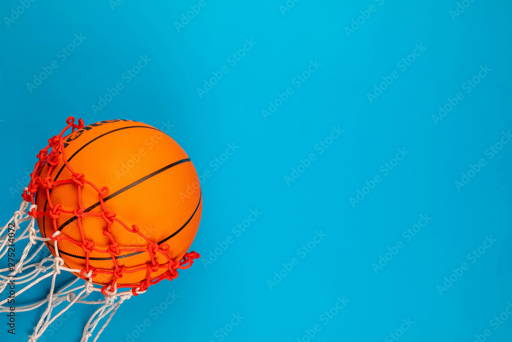 A ball passing through a basket, on blue background