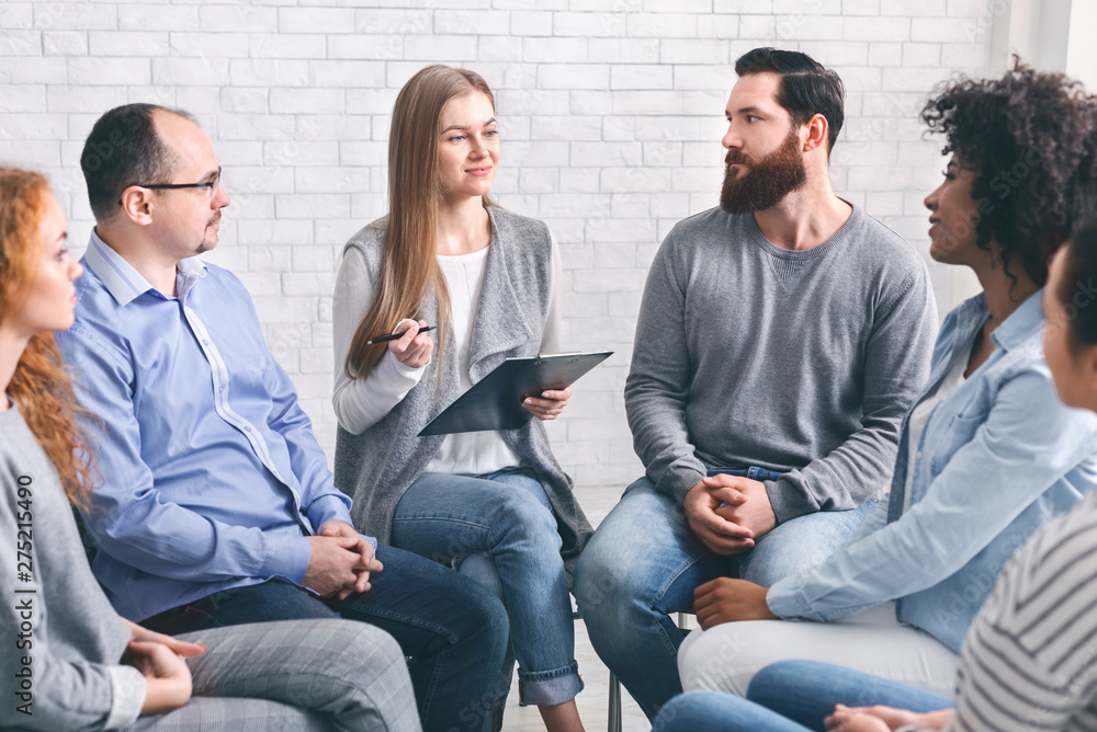 Psychologist talking to addicted people in office Psychologist talking to addicted people in office