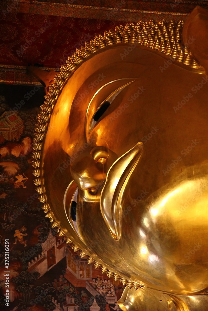 close up golden face of sleeping buddha at Wat Suthat Thailand